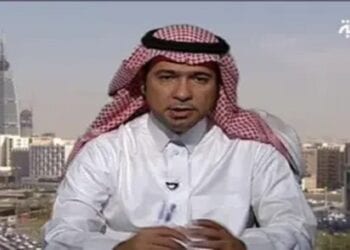 A man wearing a white thobe and red-and-white checkered ghutra sits in front of a cityscape with modern buildings. The logo of Al Arabiya is visible in the top right corner.