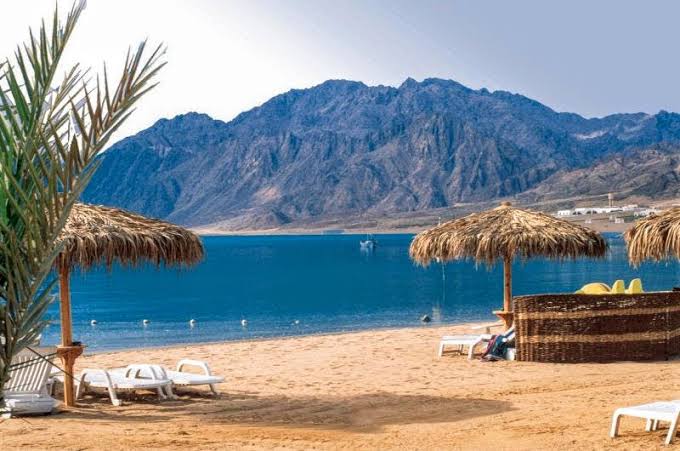 مشهد لشاطئ دهب والأنشطة البحرية والسياحية التي تجذب الزوار على ساحل البحر الأحمر