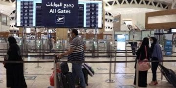 مسافرون في مطار دولي متجهون إلى وجهات سياحية متنوعة