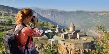 سائحة تصور منظر طبيعي لجبال ومدن أرمينيا السياحية