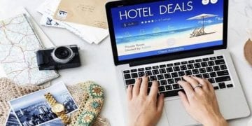 صورة توضيحية لشخص يستخدم الحاسوب لحجز فندق مع رموز أمان رقمية لتجنب عمليات الاحتيال.