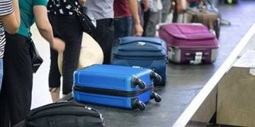 مسافرون وامامهم حقائب يد داخل صالة مطار أوروبية.