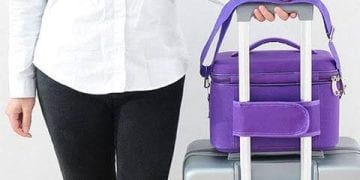 شخص يمسك حقيبة يد تحتوي على مستلزمات السفر الأساسية.