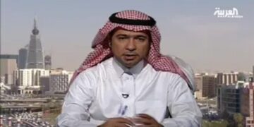 A man wearing a white thobe and red-and-white checkered ghutra sits in front of a cityscape with modern buildings. The logo of Al Arabiya is visible in the top right corner.