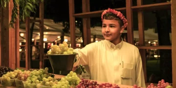 فتى يتناول أطباق شعبية عسيرية معروضة ضمن مهرجان وصل في أبها.